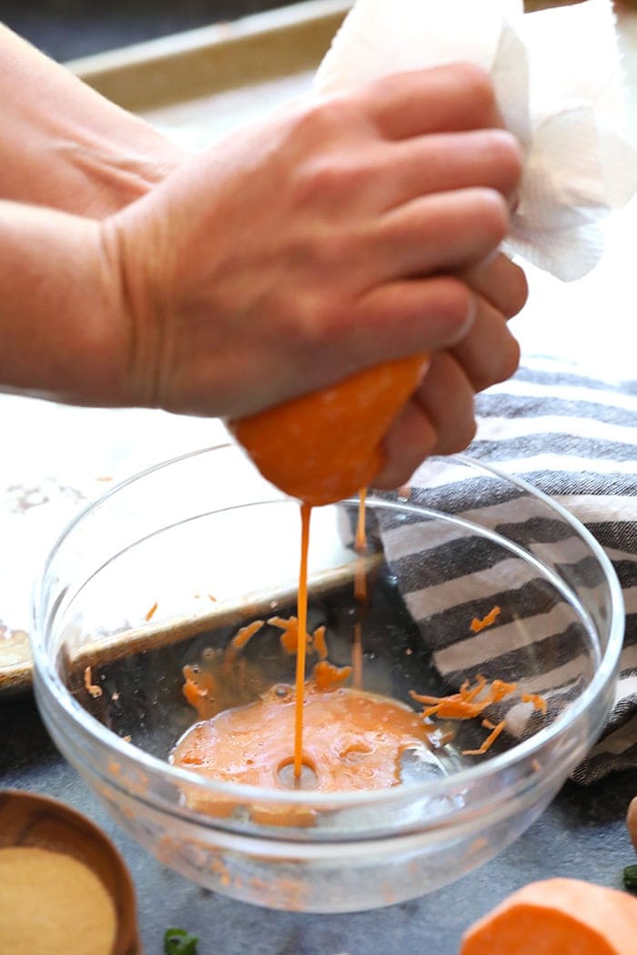 Squeezing liquid out of grated sweet potatoes.