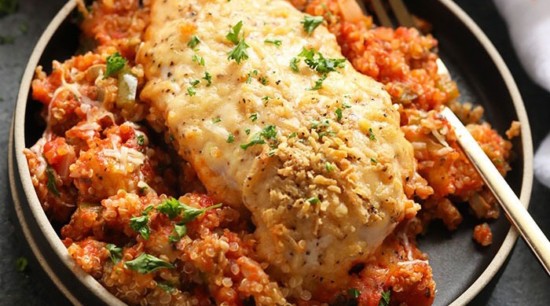 a healthy chicken dish with quinoa, tomatoes and parsley.