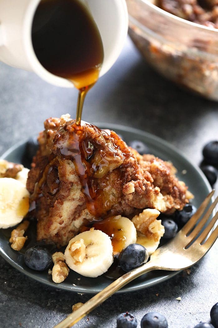 Casserole de pain perdu étant arrosée de sirop d'érable 