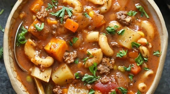 A bowl of hamburger soup with a fork.