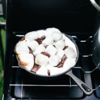 A stove with a skillet filled with marshmallows, perfect for making smores.