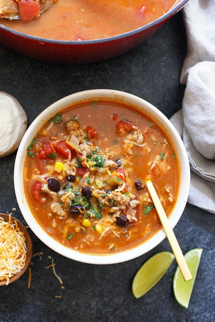 If you like tacos, you'll love this taco soup! This taco soup recipe is ready in only 30-minutes and it is a great healthy soup to make for meal-prep. Skip the spoon and scoop this soup with your favorite tortilla chip! Taco soup in a bowl.