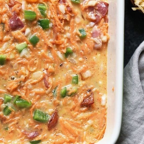 A healthy breakfast casserole with ham, cheese, and green onions.