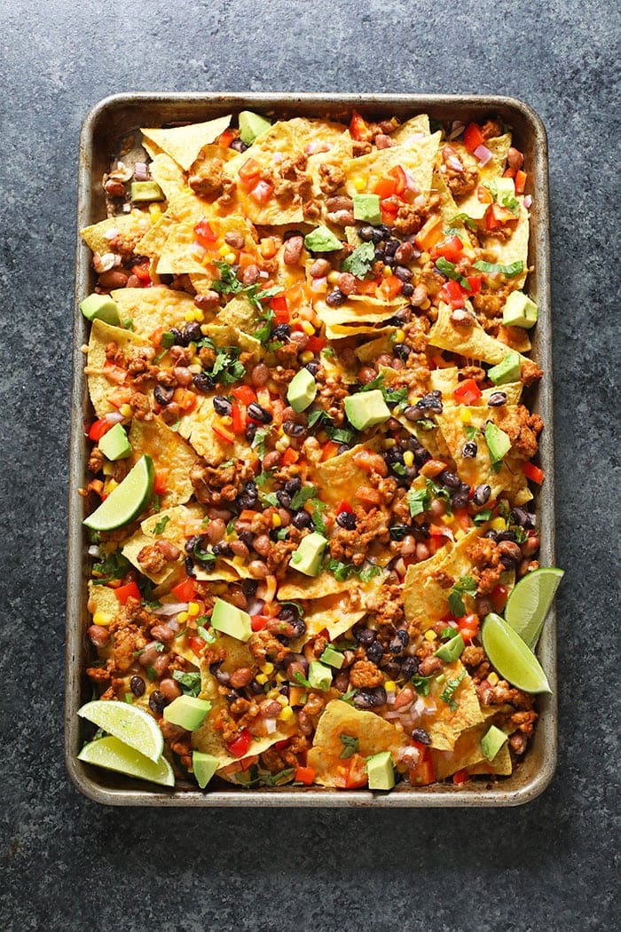 Baked chicken nachos on a baking sheet. 