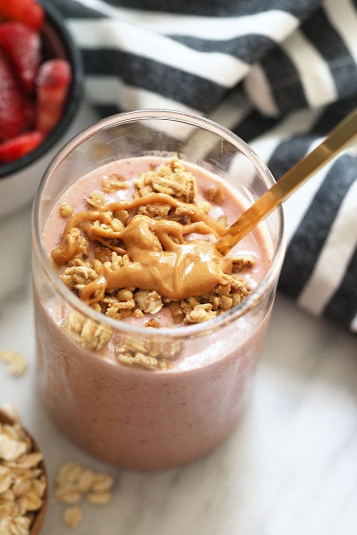 healthy breakfast smoothie in glass drizzled with peanut butter