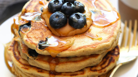 We've got an easy blueberry protein pancakes recipe for you that's made with 100% whole grains, your favorite protein powder, mashed banana, and blueberries! You'll never use another protein powder pancakes recipe again.