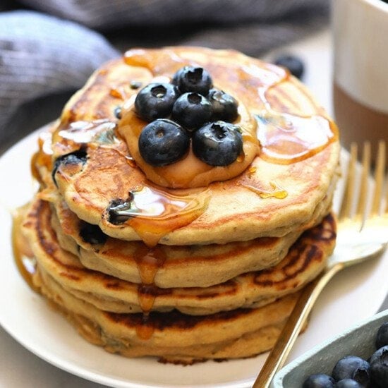 We've got an easy blueberry protein pancakes recipe for you that's made with 100% whole grains, your favorite protein powder, mashed banana, and blueberries! You'll never use another protein powder pancakes recipe again.