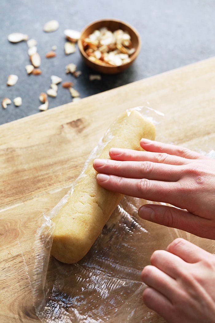 A log of shortbread cookie dough in saran wrap.