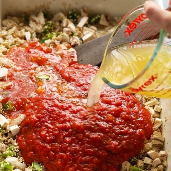 A person pouring healthy sauce into a baking dish for chicken parmesan.