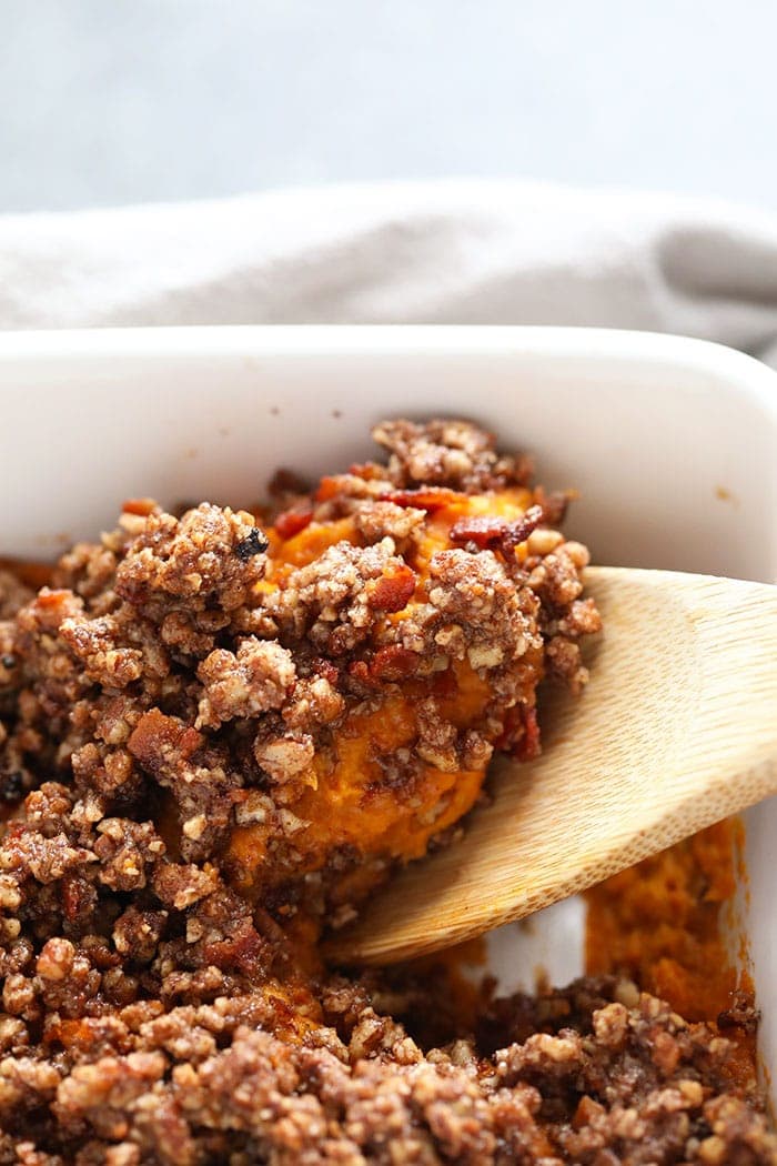 sweet potato casserole being scooped from the baking dish with a spoon