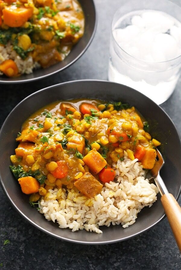 two bowls of vegan curry with rice and vegetables.