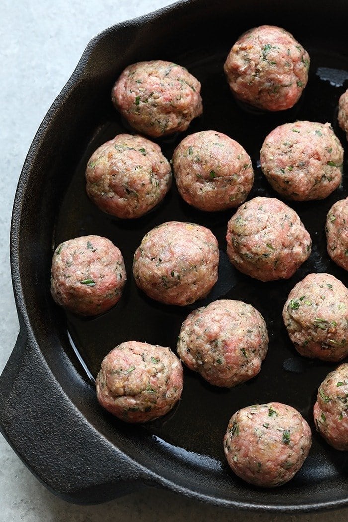 Raw meatballs in a cast iron pan