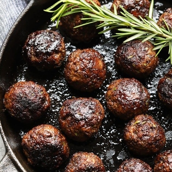 Easy meatball recipe cooked in a skillet with a rosemary sprig.