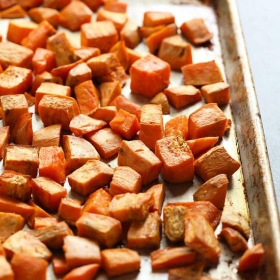 Healthy roasted sweet potatoes on a baking sheet.