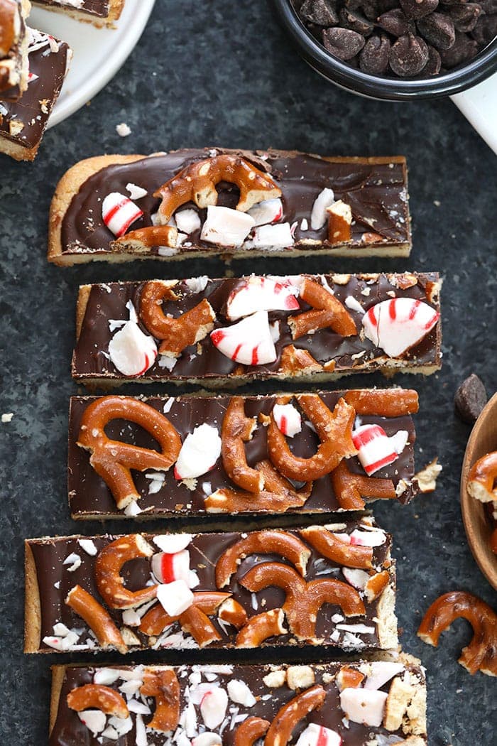 Peppermint Pretzel bars with ingredients surrounding them