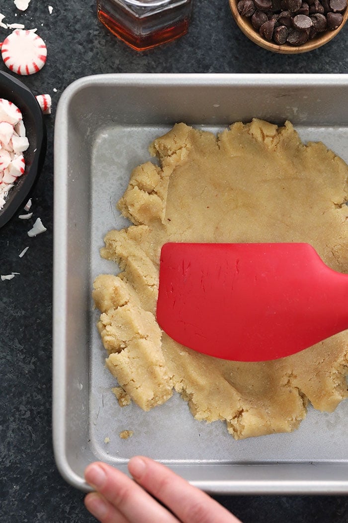 Pressing cookie crust into the bottom of the pan