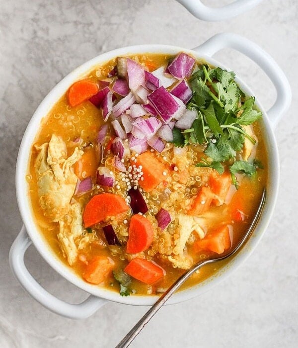 A bowl of curry chicken soup with sweet potato.