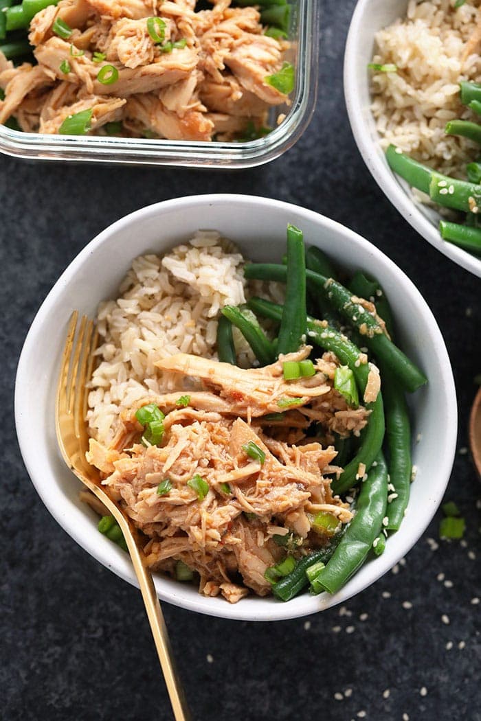 Honey garlic chicken in a bowl served over brown rice and green beans. 