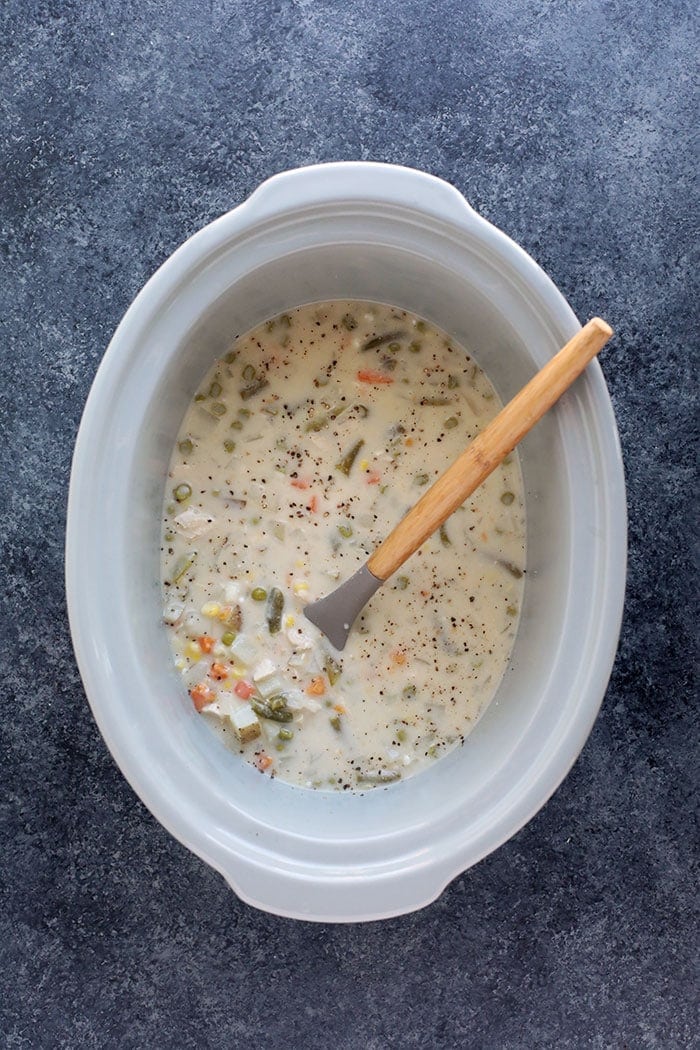 Slow cooker chicken pot pie soup with a spoon.