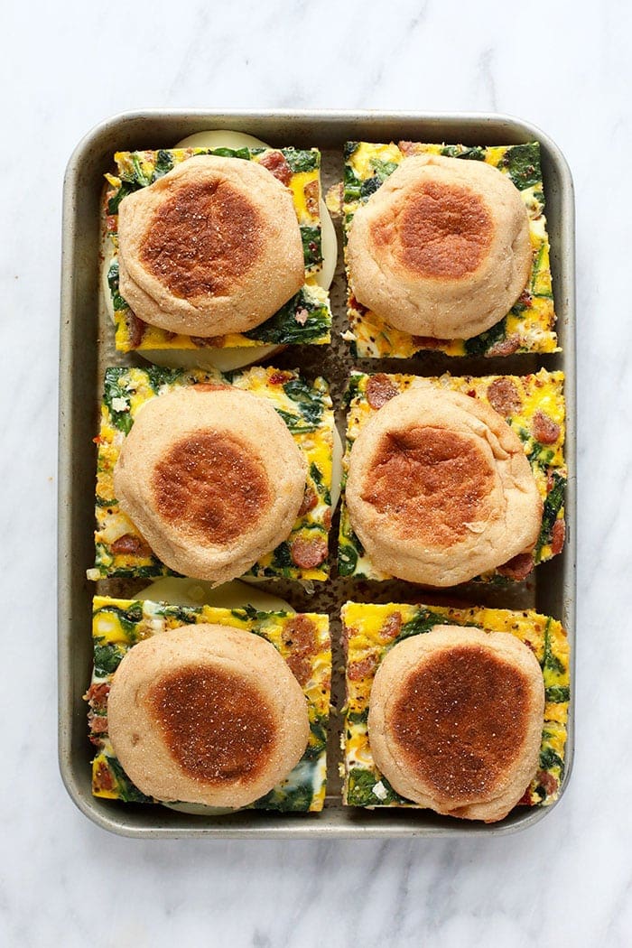 freezer breakfast sandwiches on a sheet pan ready to be wrapped and frozen