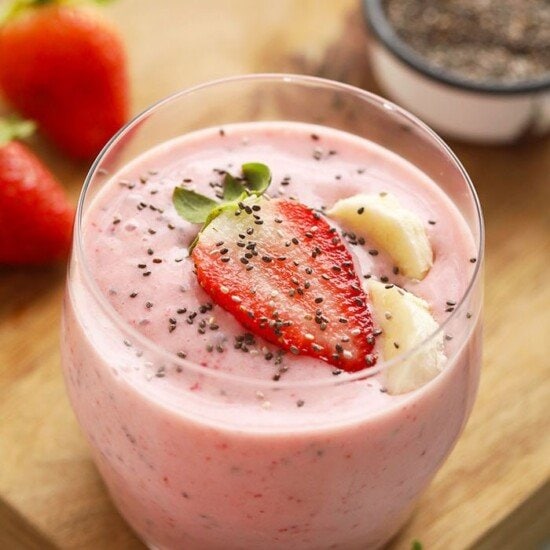 Strawberry chia smoothie in glass with strawberry on top