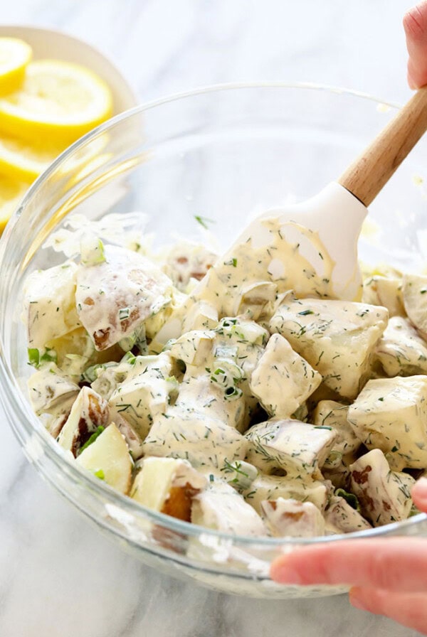vegan potato salad being stirred with a spatula