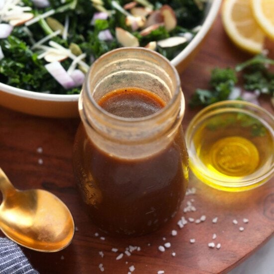 A homemade kale salad with a jar of dressing.