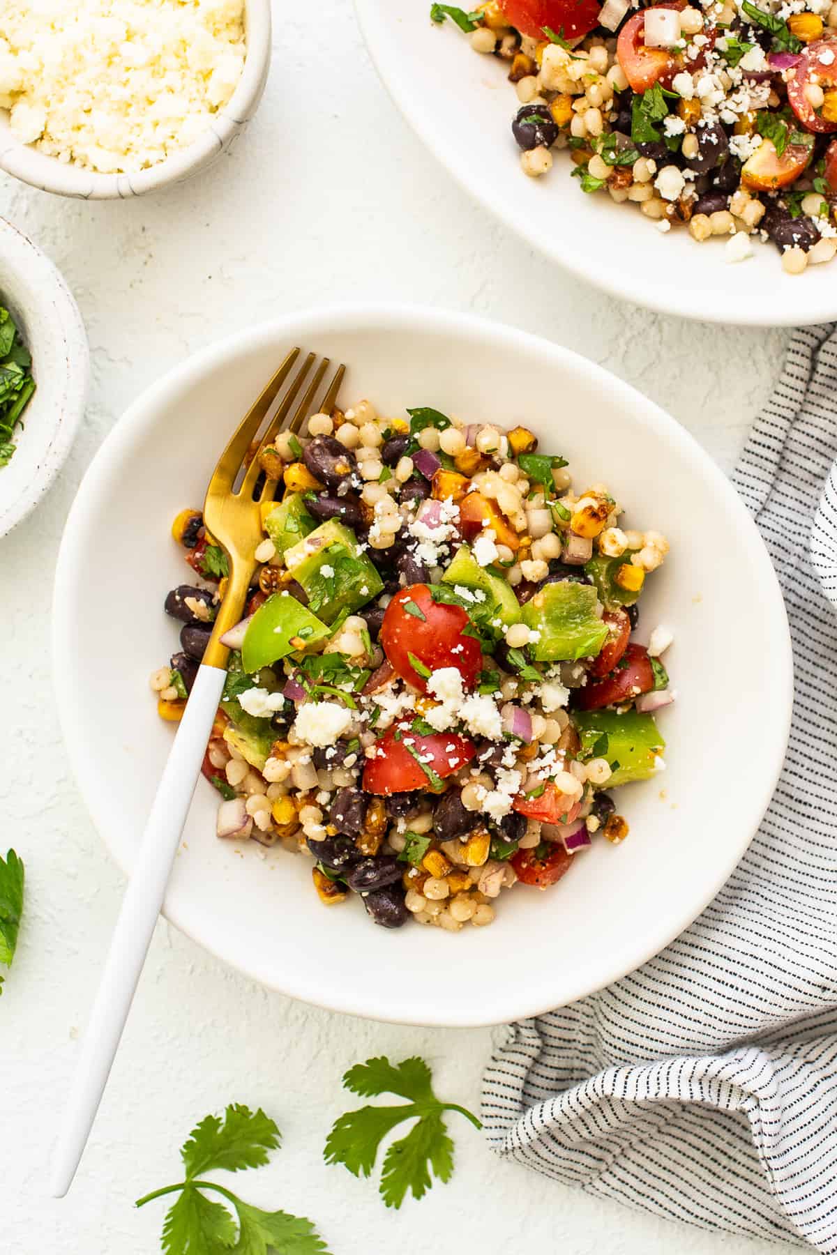 couscous salad in bowl with fork.