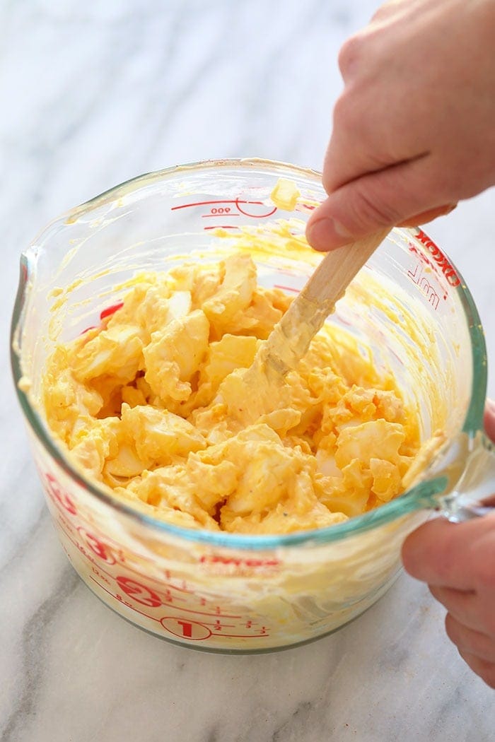 Healthy egg salad ingredients are mixed together.