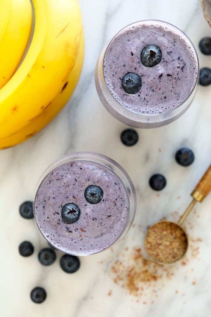 Two blueberry banana smoothies in a glass