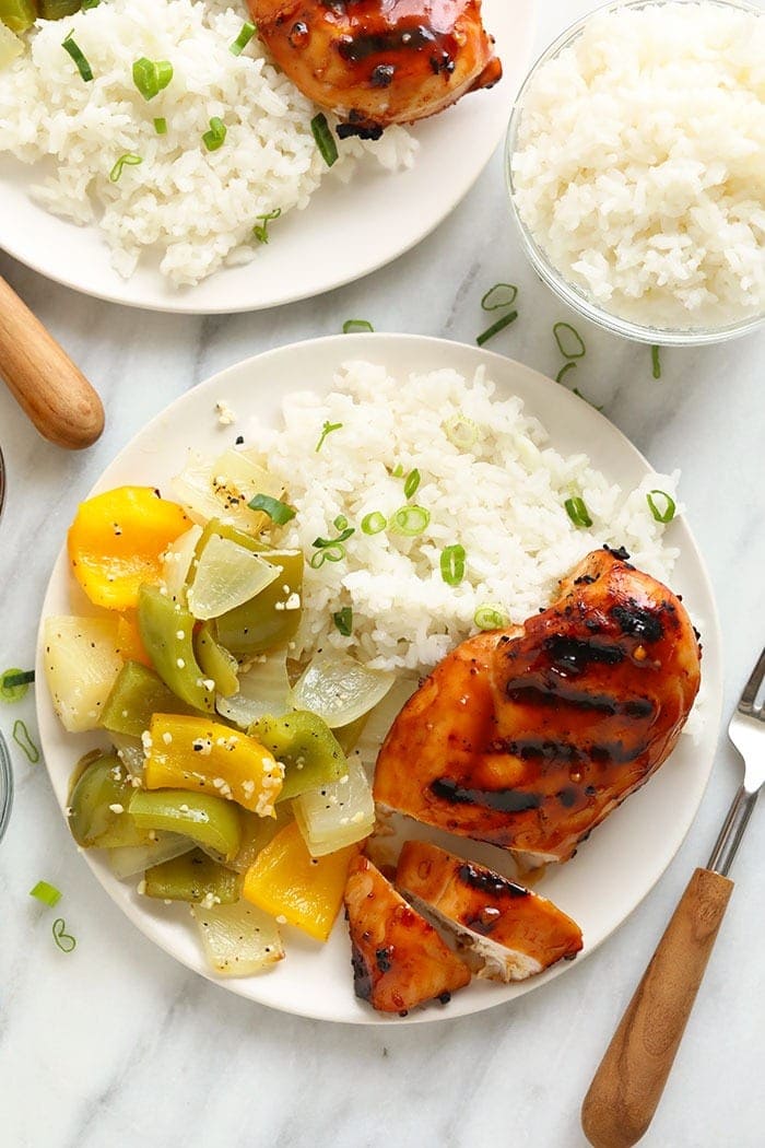 Seios de frango grelhados num prato com arroz e vegetais