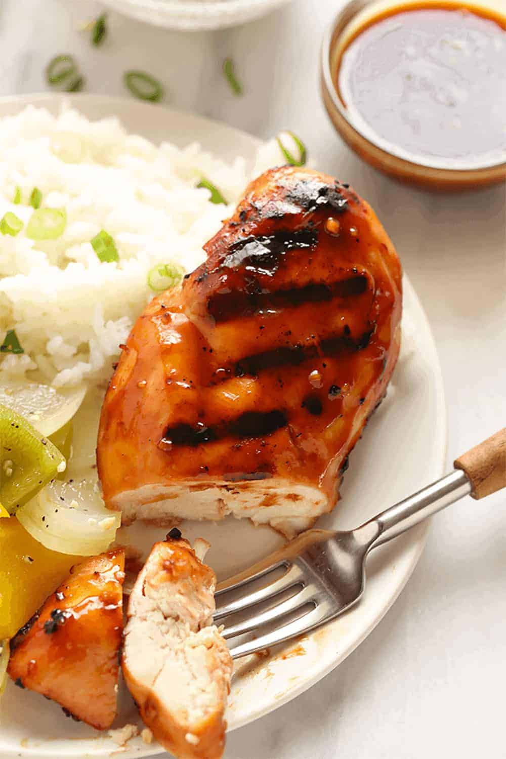 Um peito de frango teriyaki fatiado num prato