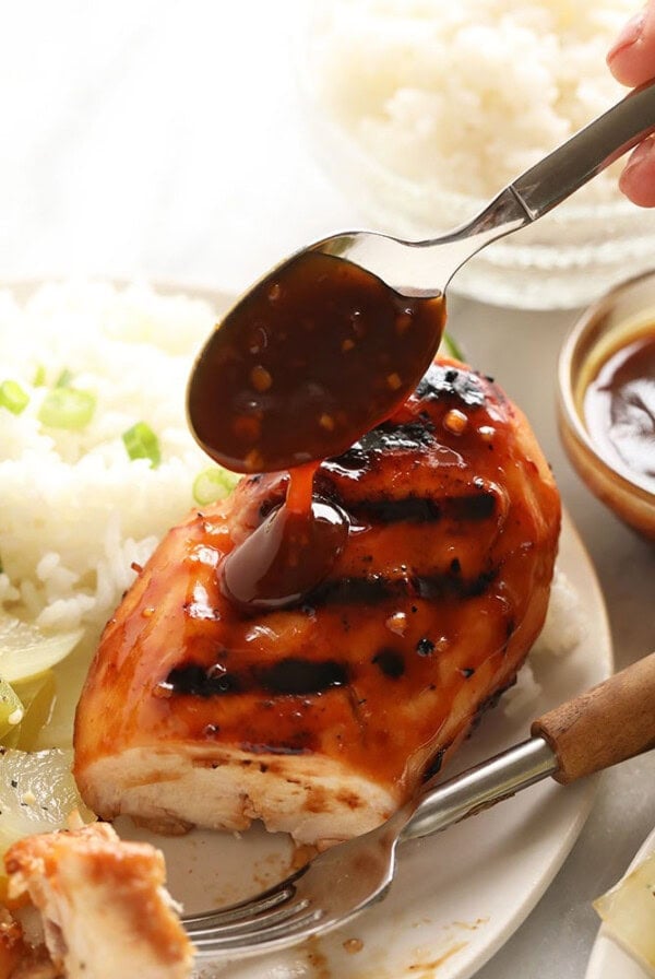 Homemade grilled chicken with BBQ sauce and homemade teriyaki sauce on a plate.