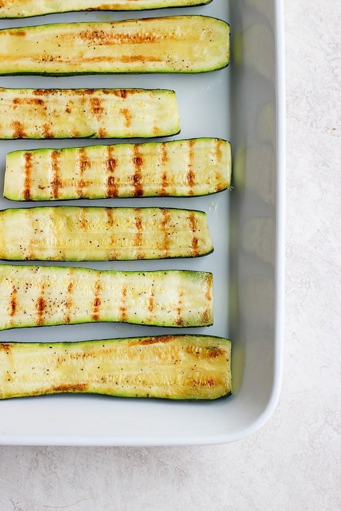 grilled zucchini in a baking dish.