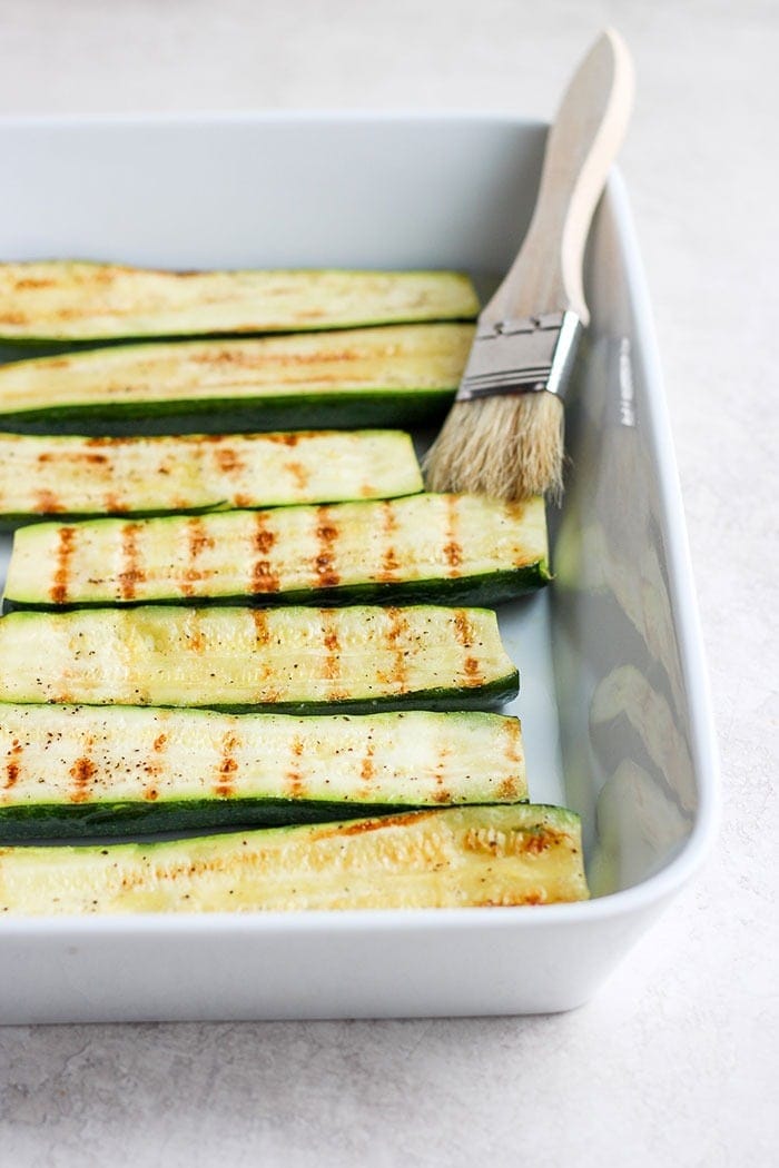 grilled zucchini in a baking dish.