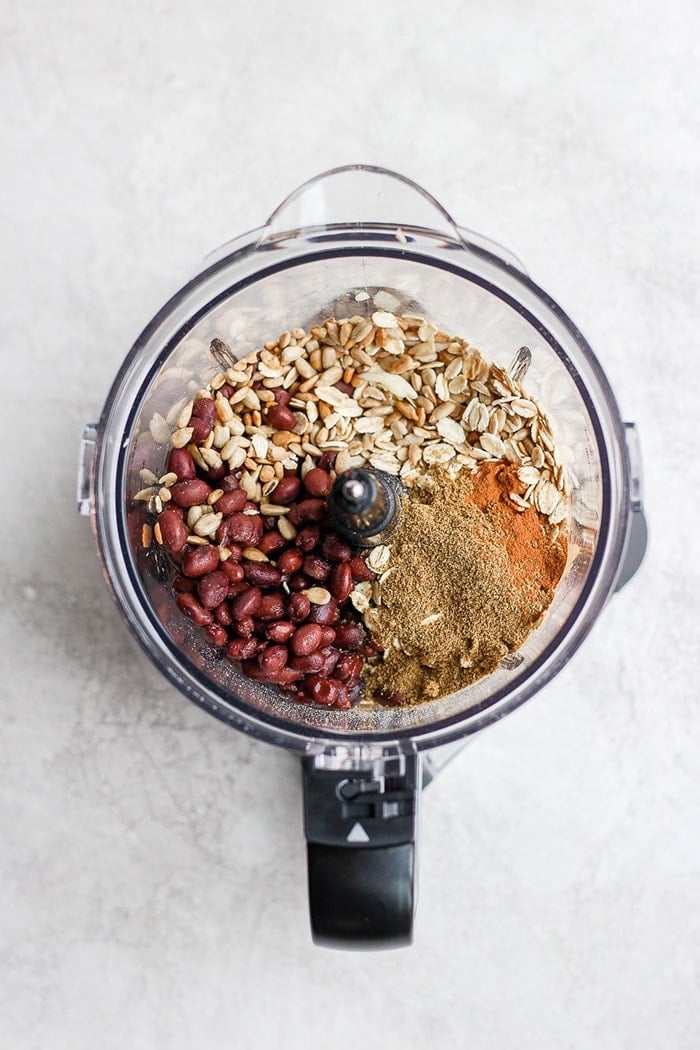 Black beans, seeds, oats, and spices in a food processor