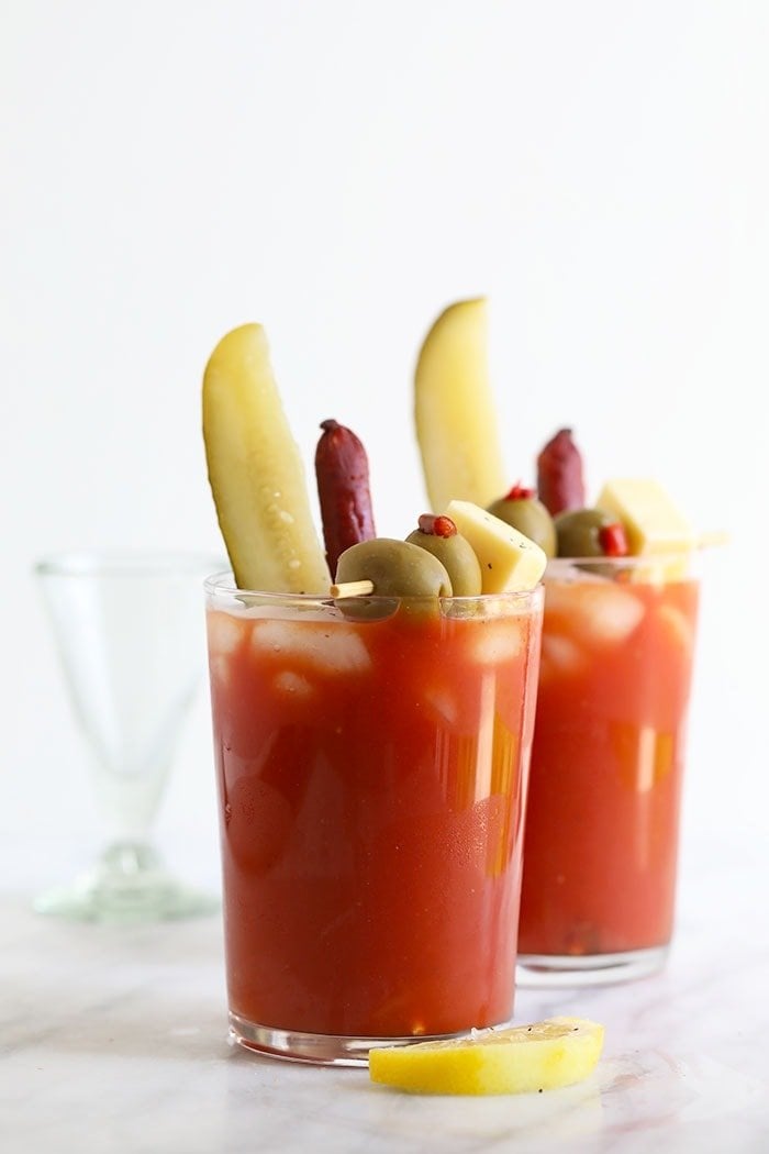 Bloody mary in a glass with pickles, olives, and cheese