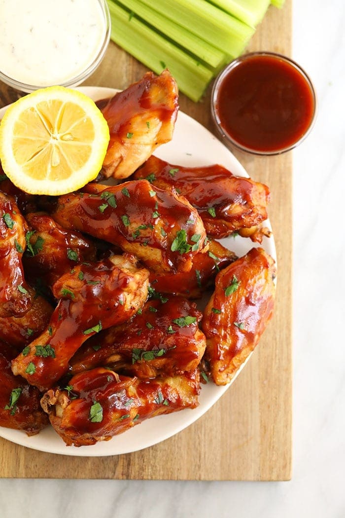 Love chicken wings but don't want to heat up your whole house? Make our amazing Crockpot Chicken Wings for your next appetizer or snack. Bonus: These Crockpot BBQ Chicken Wings aren't fried, so they're healthier! BBQ crockpot wings on a plate
