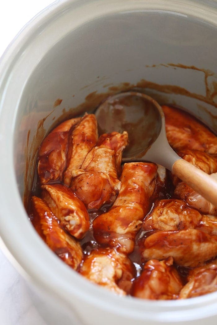 Love chicken wings but don't want to heat up your whole house? Make our amazing Crockpot Chicken Wings for your next appetizer or snack. Bonus: These Crockpot BBQ Chicken Wings aren't fried, so they're healthier! Chicken wings in sauce in crockpot