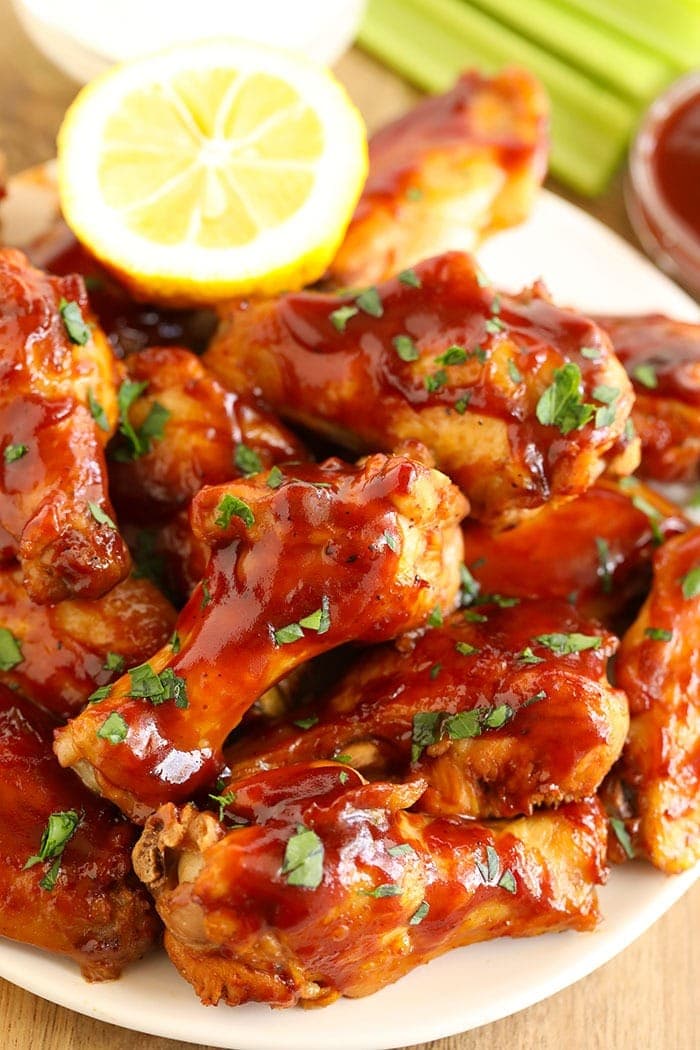 barbecue wings on a plate with lemon