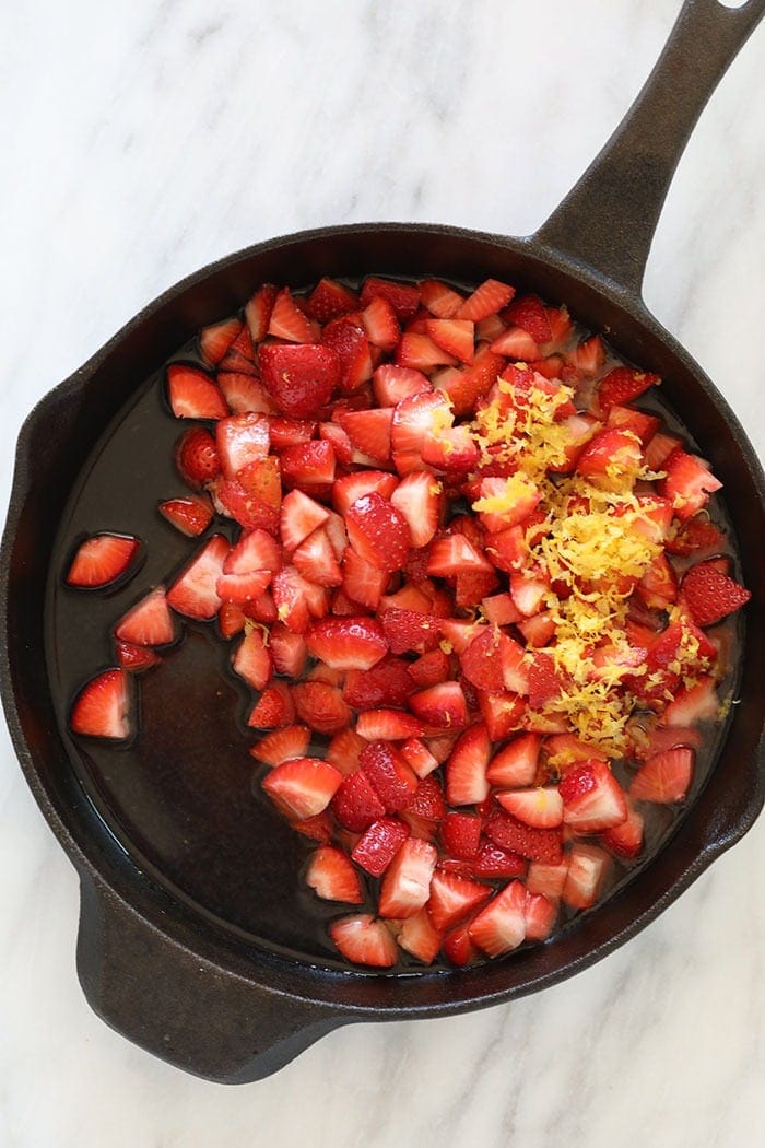 sliced strawberries in a cast iron skillet ready to be reduced