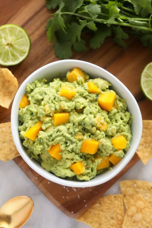 A bowl of flavorful mango guacamole served alongside tortilla chips.