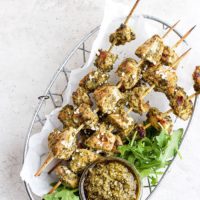chicken skewers with pesto on a plate.