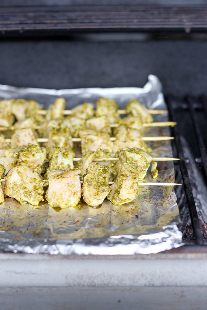 chicken skewers on a grill.
