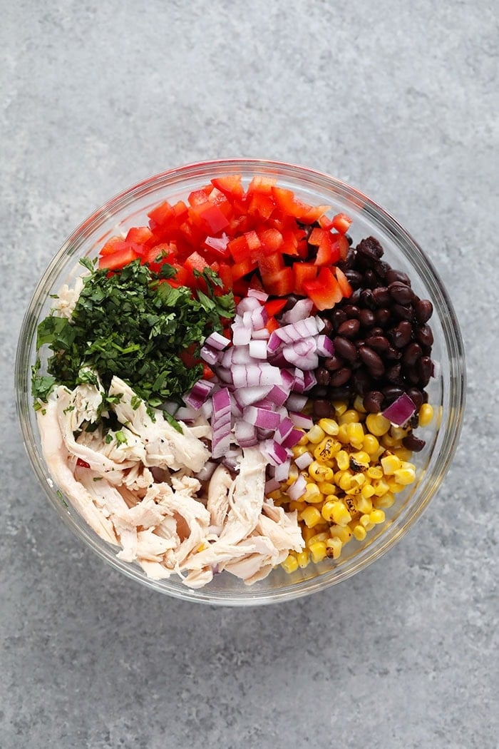 ingredients in a glass bowl of southwest salad