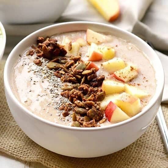A bowl of oatmeal with apples.