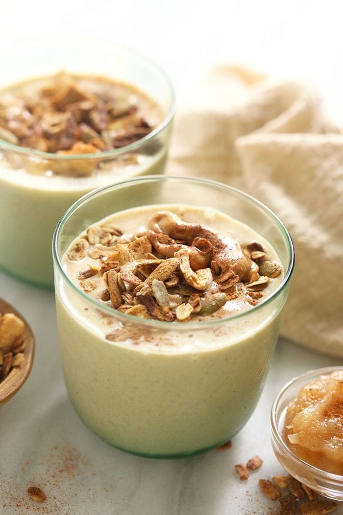 apple smoothie in a glass topped with granola