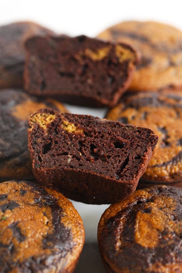 chocolate pumpkin zucchini muffins cut in half to show the swirl