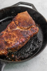 searing pork roast in cast iron skillet.