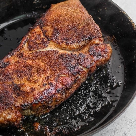 searing pork roast in cast iron skillet.